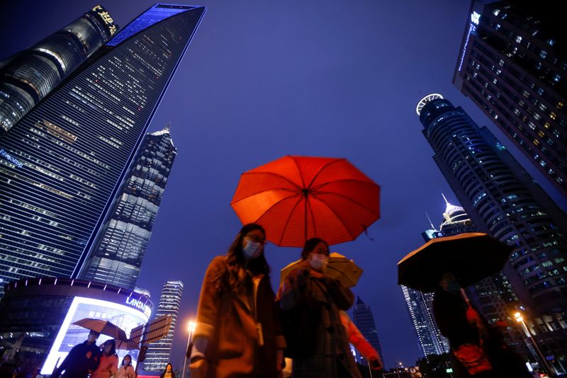 People walk with umbrellas in Lujiazui financial district in Pudong,
