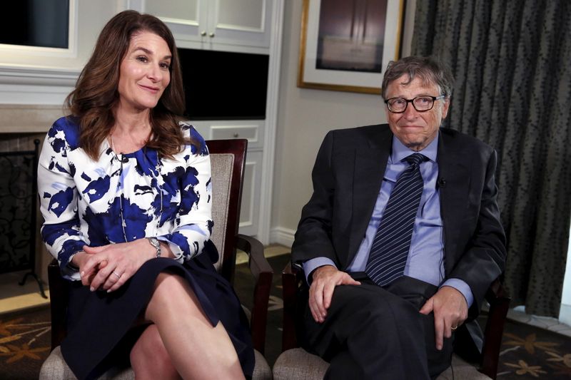 Microsoft co-founder Bill Gates and his wife Melinda sit during