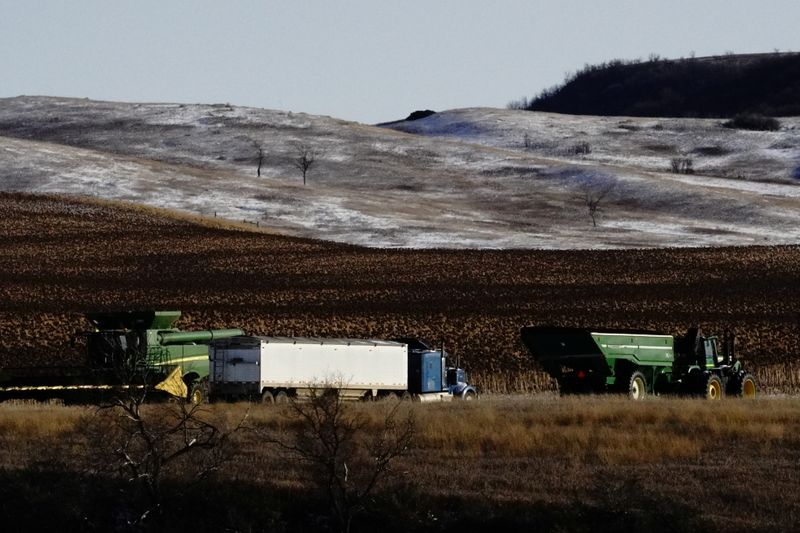FILE PHOTO: An agricultural combine, tractor and trailer, and semi
