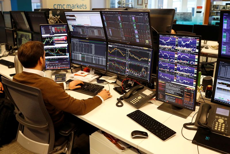 A financial trader works at their desk at CMC Markets