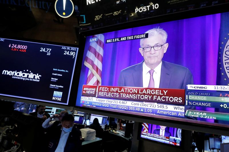 A screen displays a statement by Federal Reserve Chair Jerome