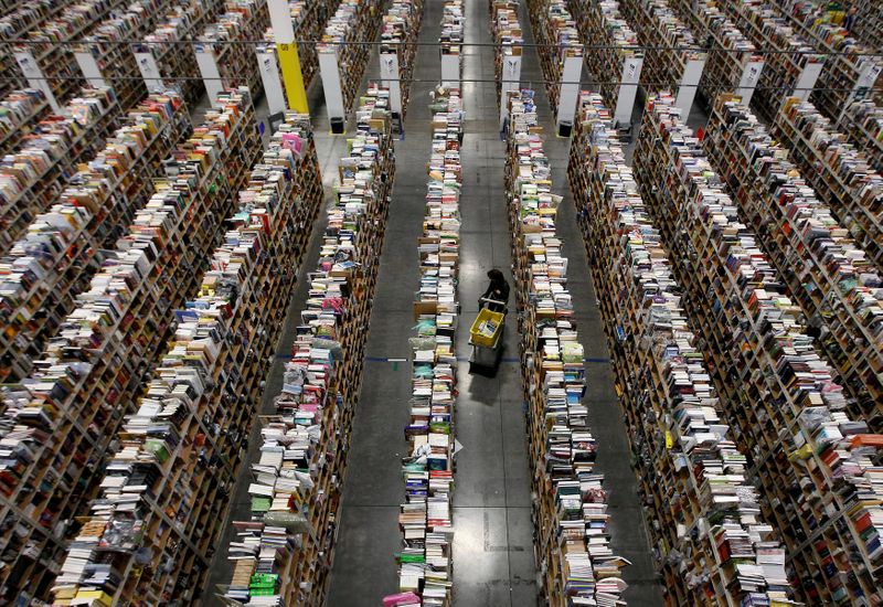 FILE PHOTO: Worker gathers items for delivery at Amazon’s distribution