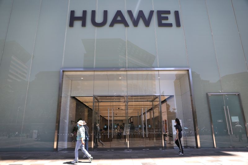 People walk past a Huawei store in Beijing