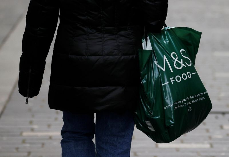 A woman carries an M&S food bag amid the outbreak