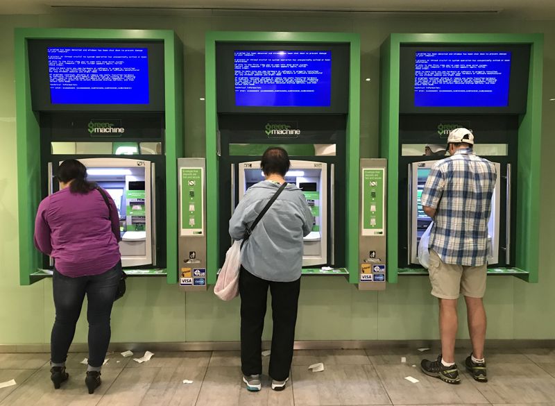 FILE PHOTO: Customers use Toronto Dominion (TD) Bank ATM cash