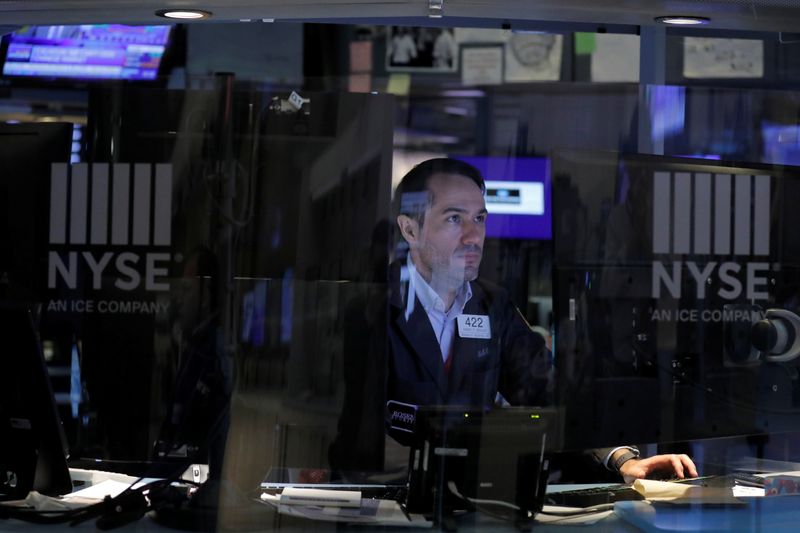 A trader works behind plexiglass on the floor of the