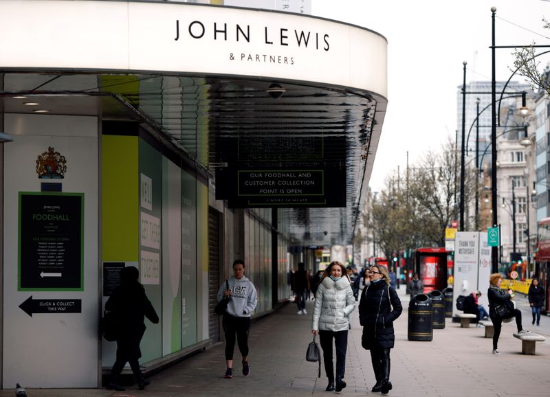 People walk past a temporarily closed John Lewis department store
