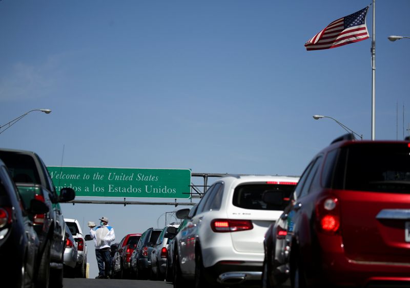 Vehicles wait in line to cross into the U.S, in