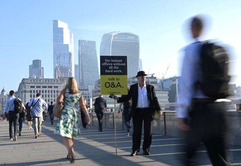 FILE PHOTO: Workers walk towards the City of London financial