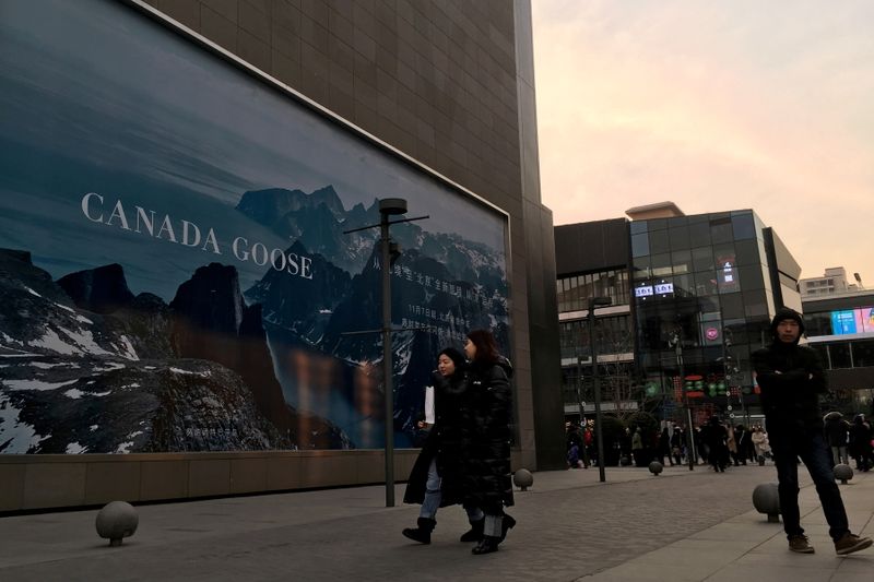 FILE PHOTO: People walk past an advertisement near the flagship