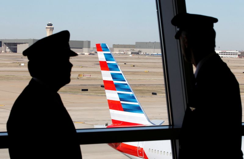 FILE PHOTO: Pilots talk as they look at the tail