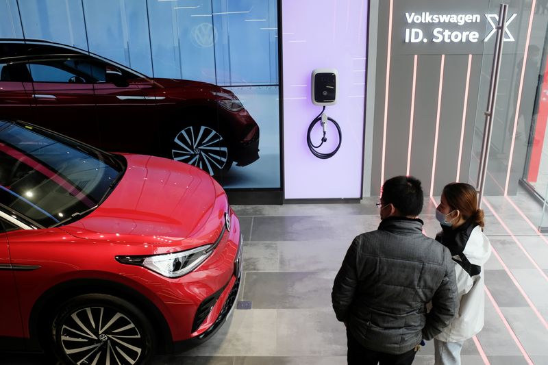 FILE PHOTO: People check a Volkswagen ID.4 X electric vehicle