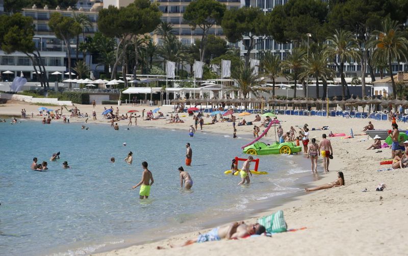 FILE PHOTO: People sunbathe at Magaluf beach in Mallorca