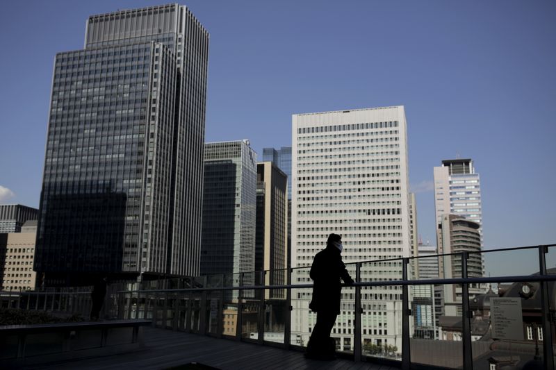 A businessman stands on a terrace overlooking a banking district
