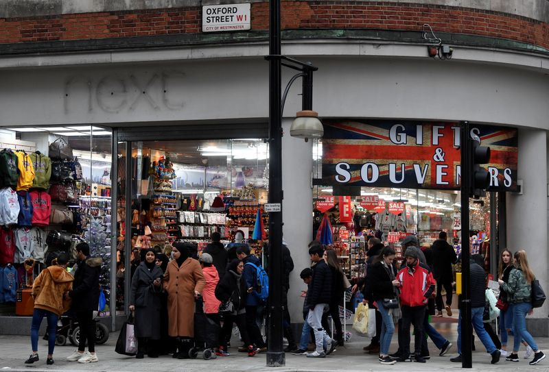 Shoppers walk past a former branch of the British clothing