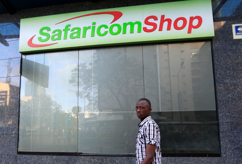FILE PHOTO: A man walks past Safaricom shop, a mobile