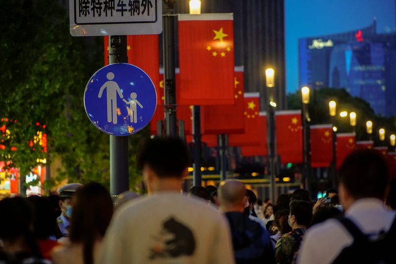 People walk along Nanjing Pedestrian Road, a main shopping area,