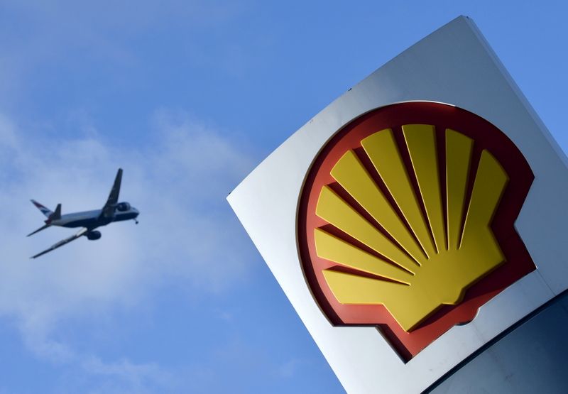 FILE PHOTO: Passenger plane flies over a Shell logo at