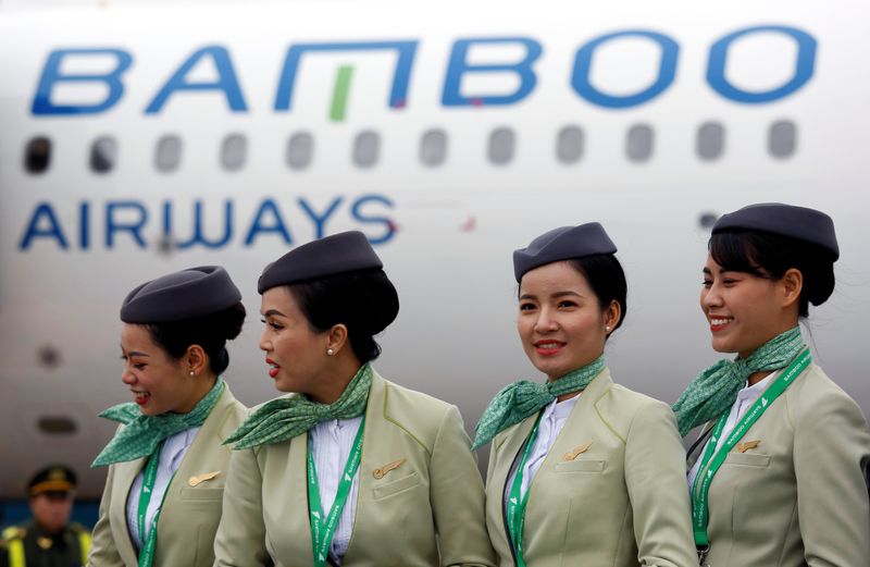 Crew members stand near an Airbus A321 aircraft of Bamboo