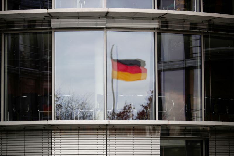 FILE PHOTO: A German flag is reflected in the window