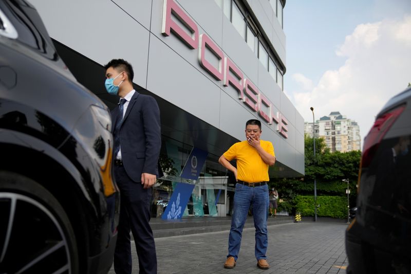 Guo Hui looks at his Porsche Cayenne he is selling