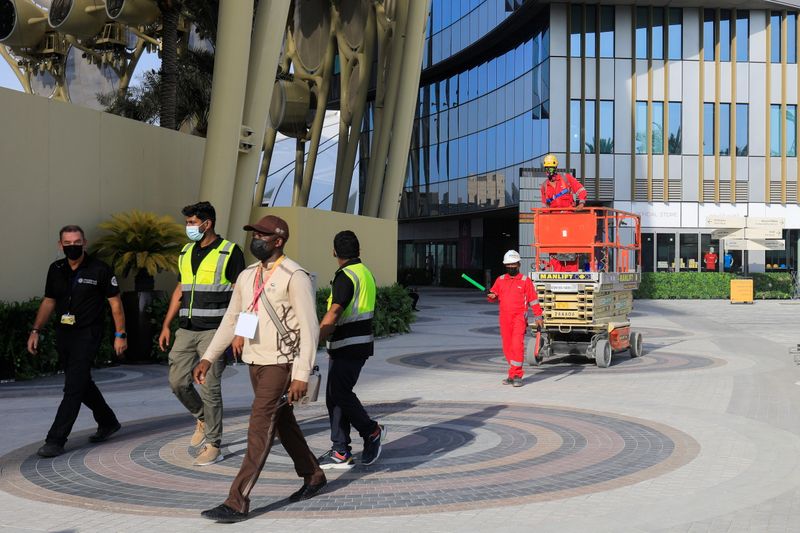 FILE PHOTO: Workers walk at the Expo 2020 site ahead