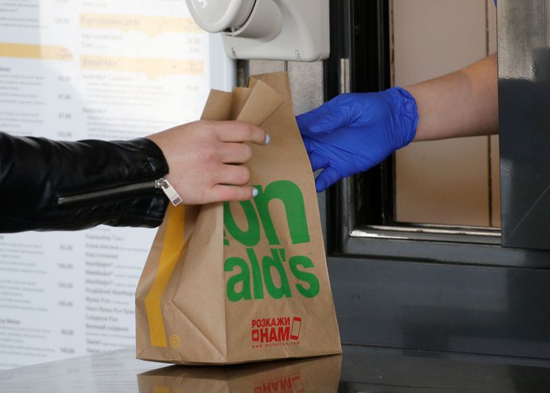 A woman picks up a food order outside a McDonald’s