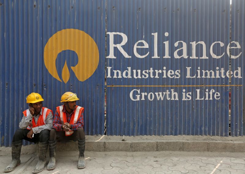 FILE PHOTO: Labourers rest in front of an advertisement of