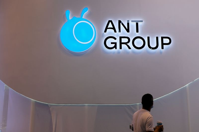FILE PHOTO: A man walks past an Ant Group logo