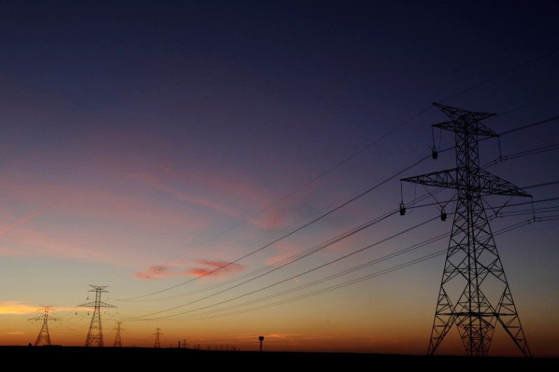 FILE PHOTO: The sun sets behind power lines above the