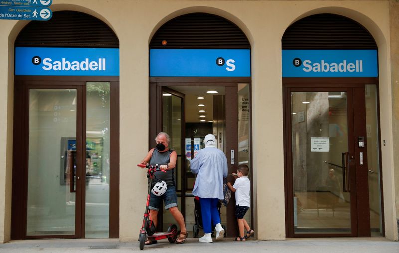 FILE PHOTO: People walk at the door of a Sabadell