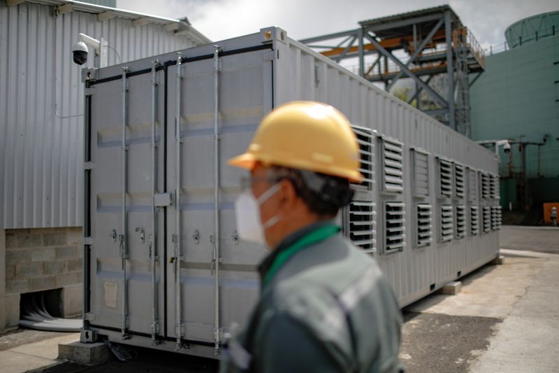 A worker is seen next to a container, where a