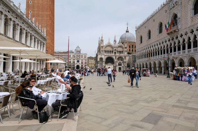 FILE PHOTO: People sit at outdoor tables in St. Mark’s