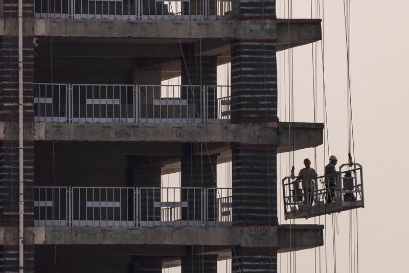 Men work at the construction site of a highrise building