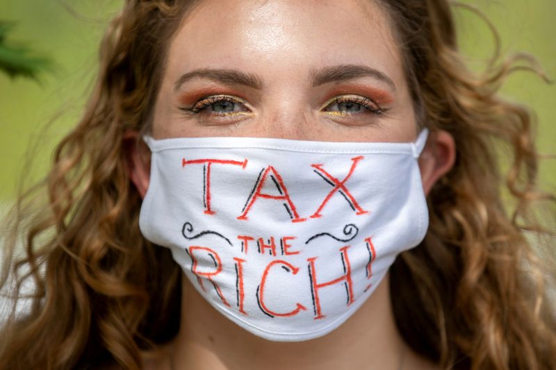 FILE PHOTO: NDP supporter wears “Tax the Rich” mask