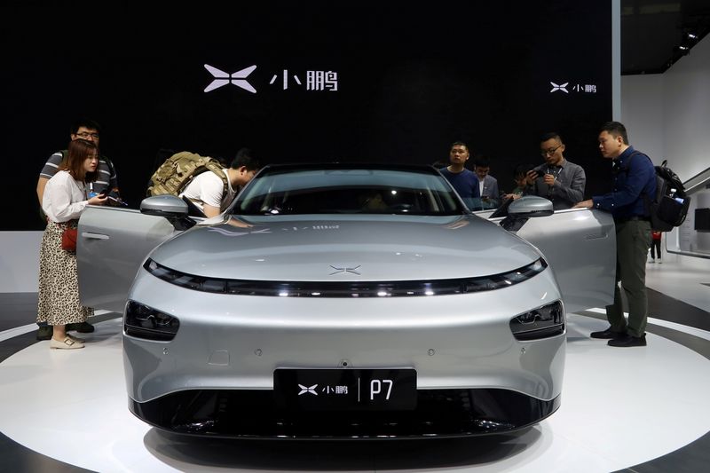 FILE PHOTO: People look at XPeng’s P7 sedan model displayed