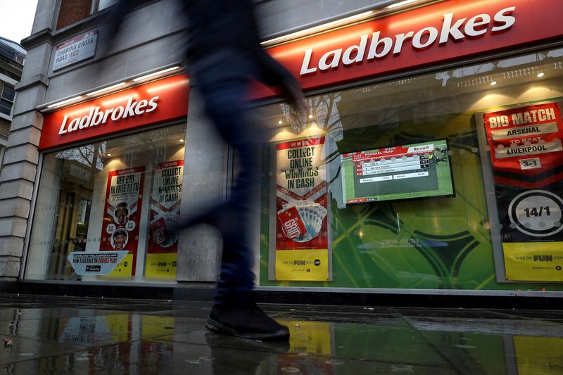 FILE PHOTO: A pedestrian walks past a branch of Ladbrokes