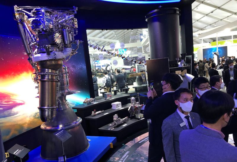 Participants looks at a display of rocket engines and other