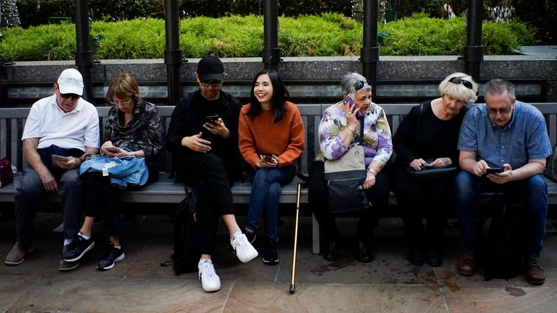 People look at their smartphones at the Rockefeller center in