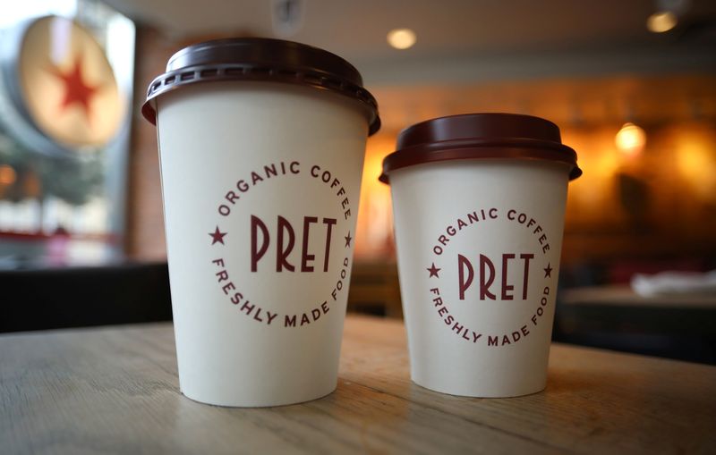 Take-away coffee cups stand on a table inside a Pret