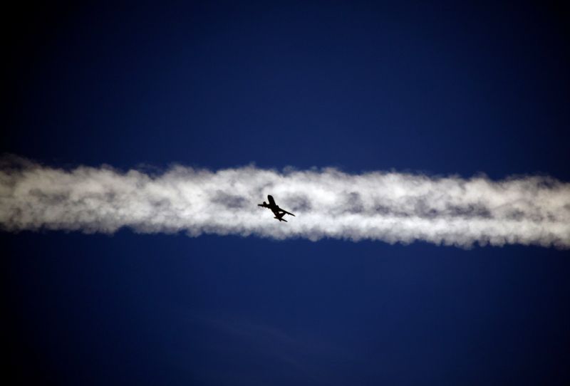 FILE PHOTO: An aeroplane flies underneath the jet stream of