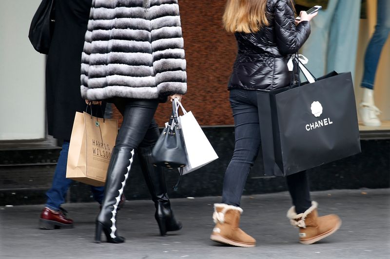 Customers carry shopping bags with purchases outside a department store
