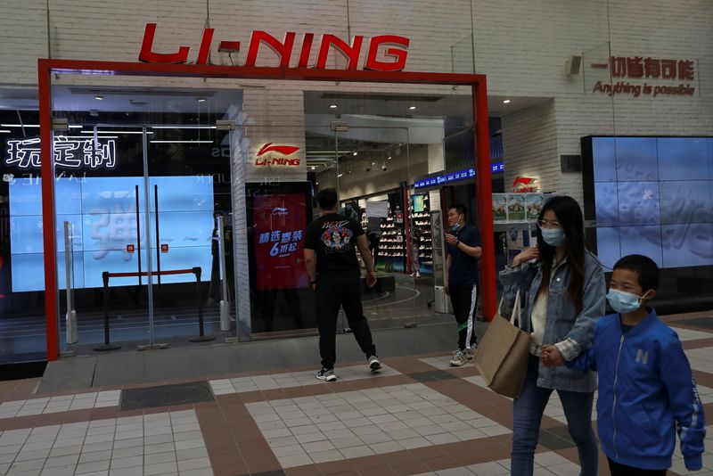 People walk past a store of Chinese sports products brand