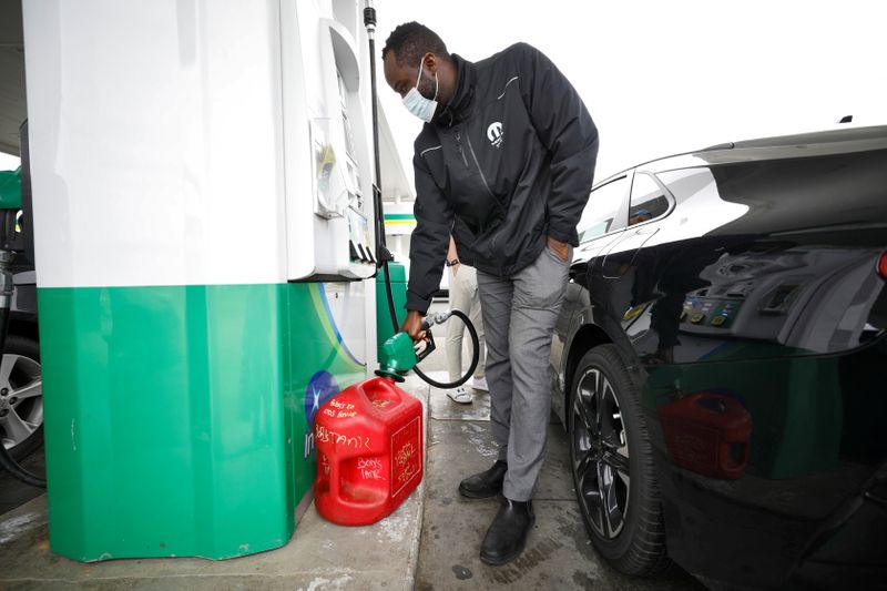 Resident fills up portable gas container at fuel station during