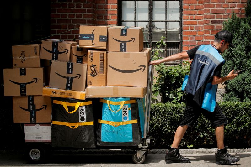 FILE PHOTO: An Amazon delivery worker pulls a delivery cart