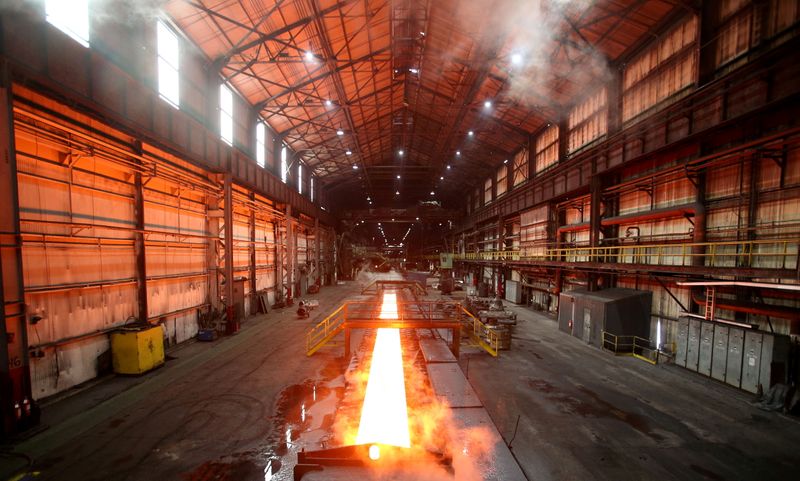 FILE PHOTO: Steam rolls off a slab of steel as