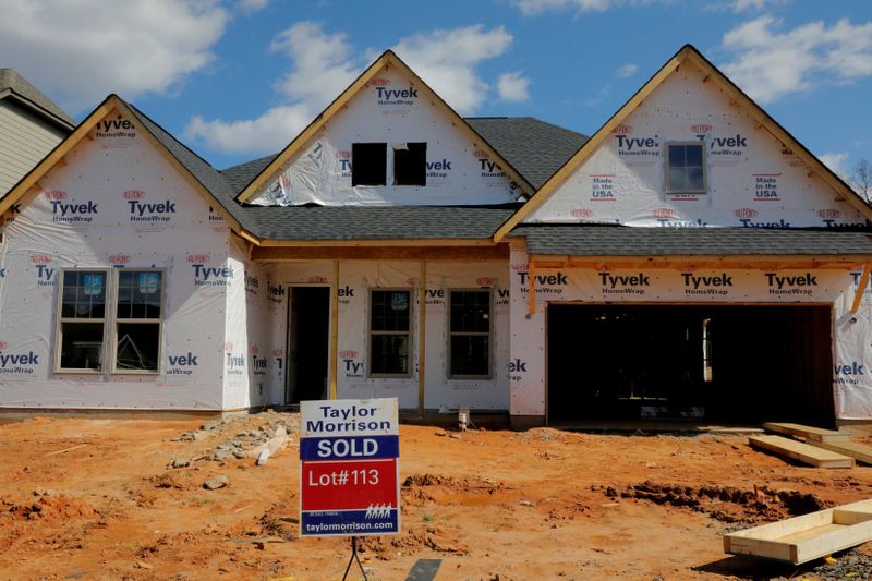 FILE PHOTO: A home under construction stands behind a “sold”