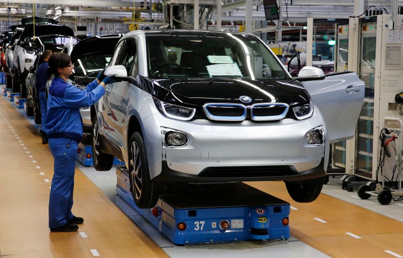 A worker makes final checks at the serial production BMW