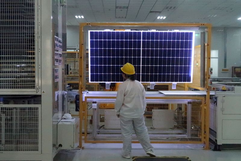Worker conducts quality-check of a solar module product at a