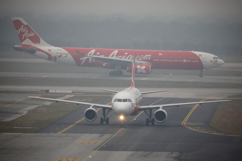 FILE PHOTO: Air Asia airplanes are pictured on the haze-shrouded